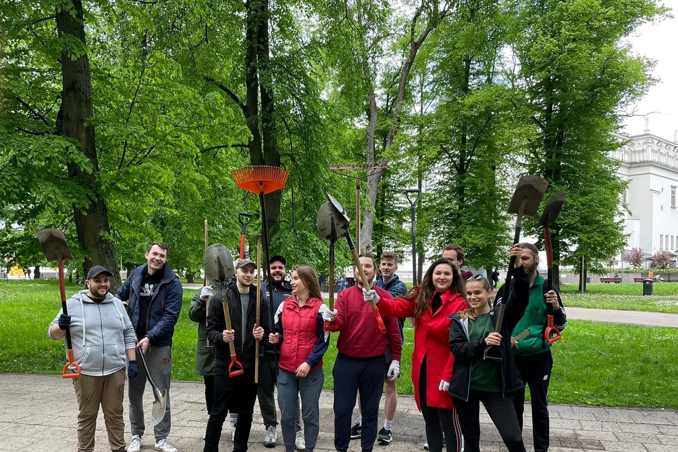 Savanoriai Sereikiškių parke mojuoja darbo įrankiais - grėbliais. Visi šypsosi ir nusiteikę talkai.