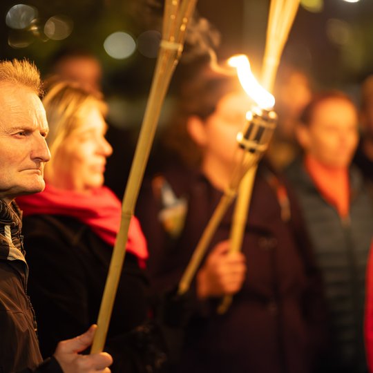 Vienas iš ekskursijos dalyvių, laikantis fakelą.