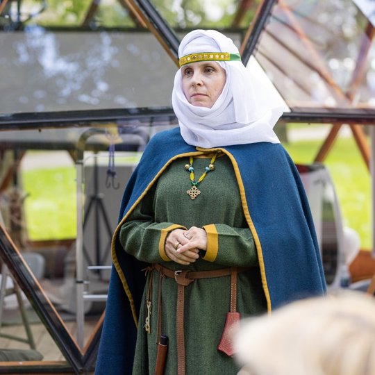 Nuotraukoje matoma moteris, aprengta viduramžių kostiumu.