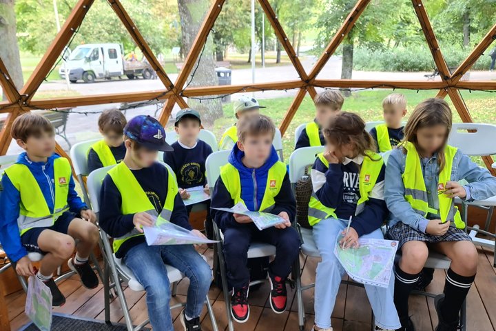 Mokiniai tyrinėja VIlniaus pilių planus kupole, klausydamiesi instruktažo.