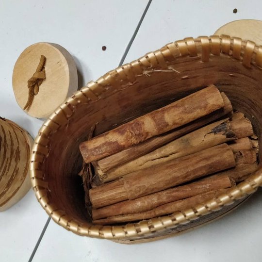 Ant stalo padėti du krepšeliai ir medinis indelis. Didesniame krepšelyje sudėta cinamono lazdelės, mažesniame indelyje kardamonas, o indelyje džiovintos citrinų skiltelės.