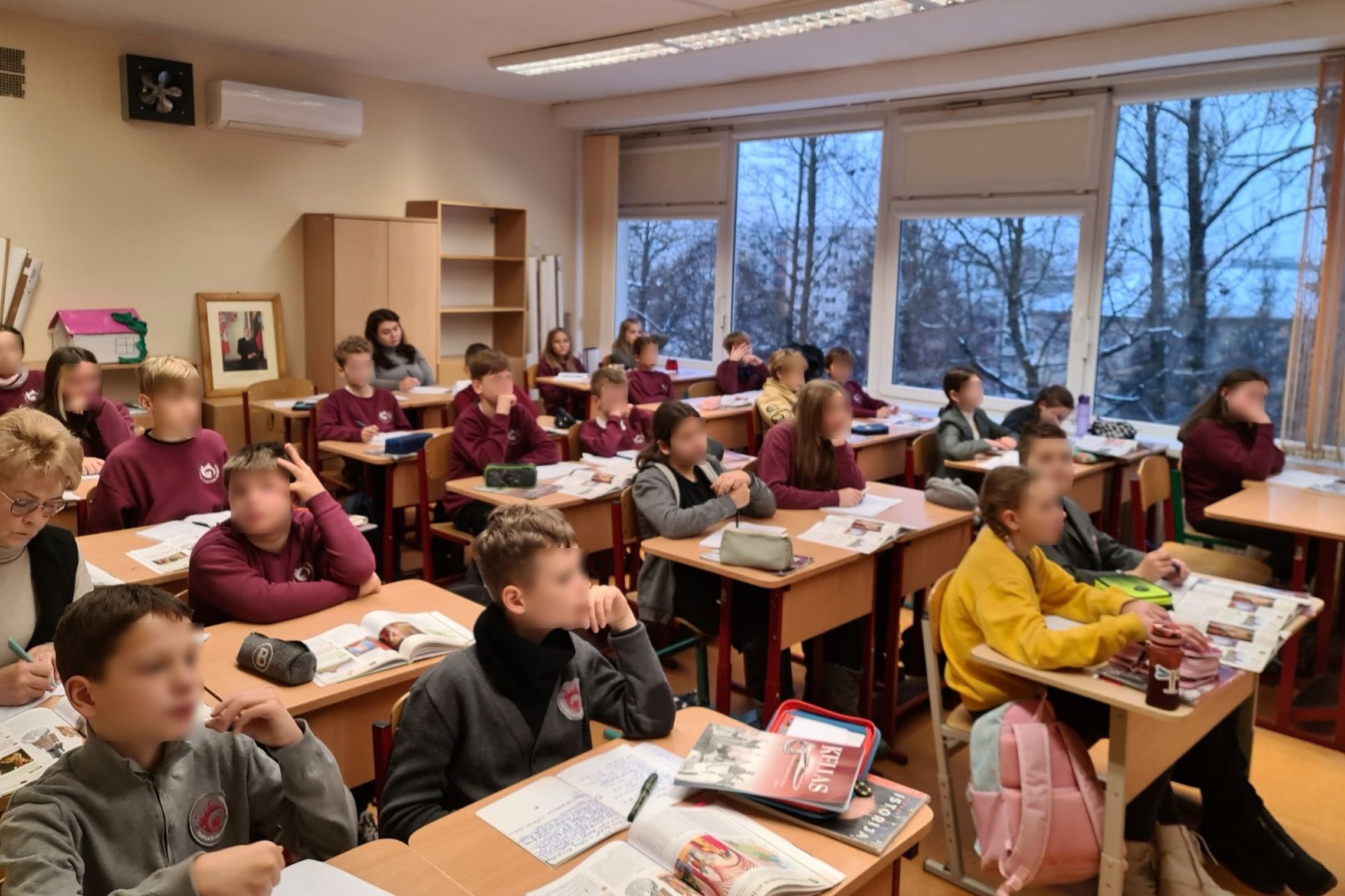 Penktokai klasės suoluose, per istorijos pamoką klausosi pasakojimo apie Gedimino darbus Vilniuje.
