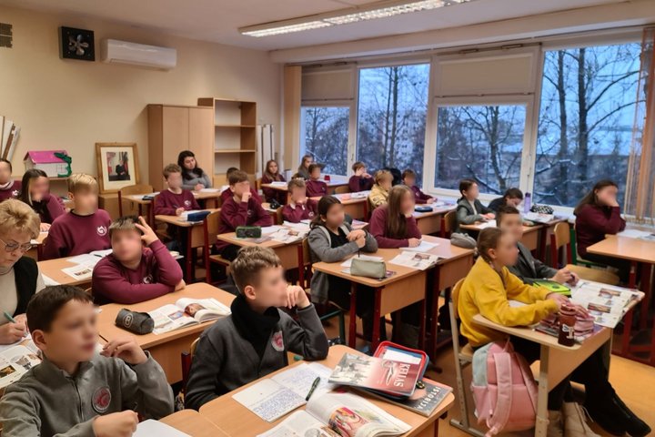Penktokai klasės suoluose, per istorijos pamoką klausosi pasakojimo apie Gedimino darbus Vilniuje.