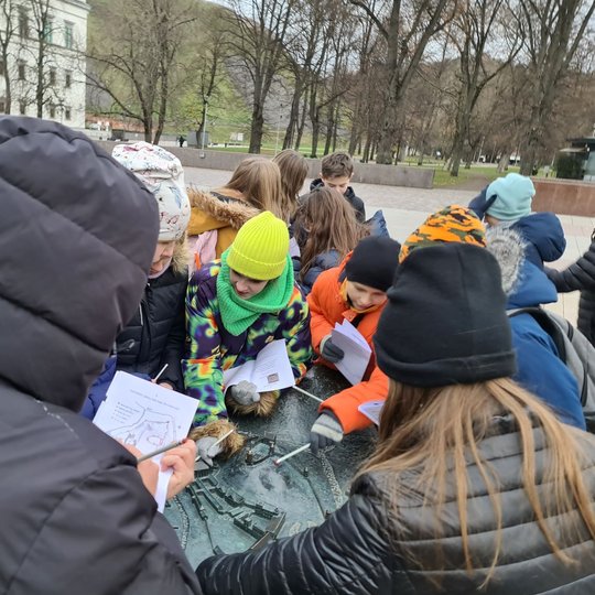 Orientacinio žaidimo pradžia. Vaikams dalinami lapai su užduotimis.
