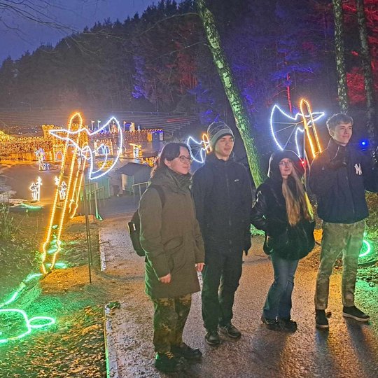 Mokiniai pozuoja prie šviečiančių instaliacijų, tarp Karigailos kalvos ir Stalo kalno.