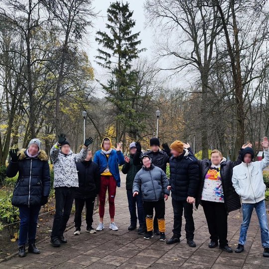 Vilniaus Vilties mokyklos auklėtiniai mojuoja iš Pilių parko. Jie sustoję ant takelio.