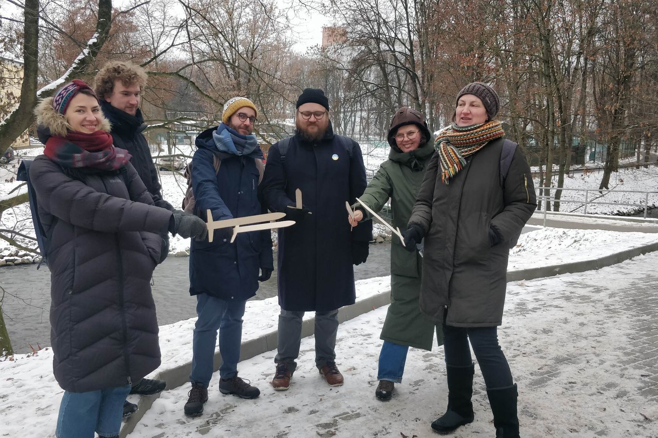 Vilniaus miesto muziejaus komanda kartu su Vilniaus pilių rezervato darbuotojais pozuoja nuotraukai su mediniais kalavijais.