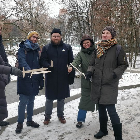Vilniaus miesto muziejaus komanda kartu su Vilniaus pilių rezervato darbuotojais pozuoja nuotraukai su mediniais kalavijais.