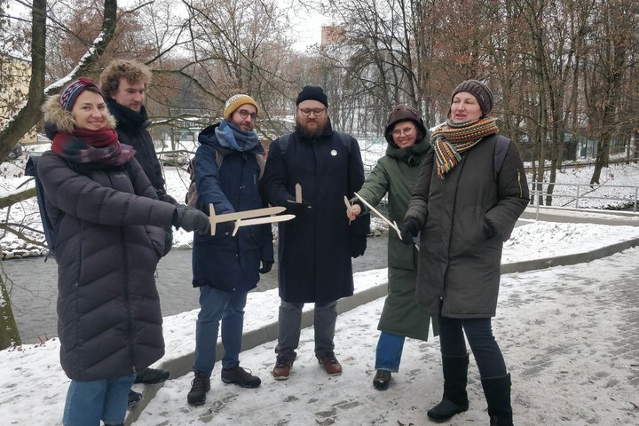 Vilniaus miesto muziejaus komanda kartu su Vilniaus pilių rezervato darbuotojais pozuoja nuotraukai su mediniais kalavijais.