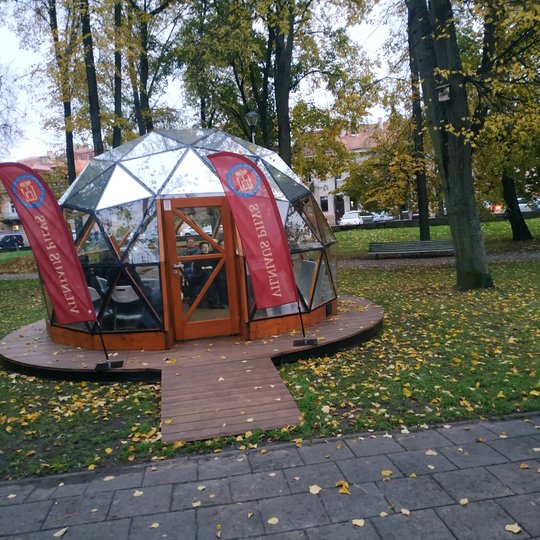 Vilniaus pilių kupolas iš lauko. Šalia įėjimo vėliavos. Rudens vakaras.
