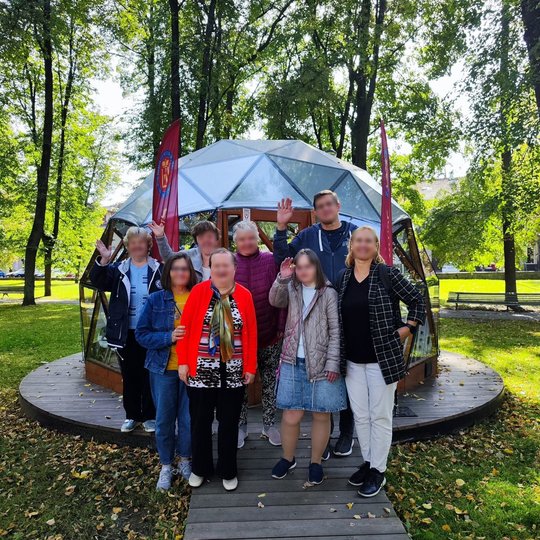 Žaluma žėrinčiame parke, priešais tviskantį, stiklinį, iš trikampių sudarytą kupolą, šypsosi bei mojuoja aštuoni Vilniaus pilių edukacijos dalyviai.