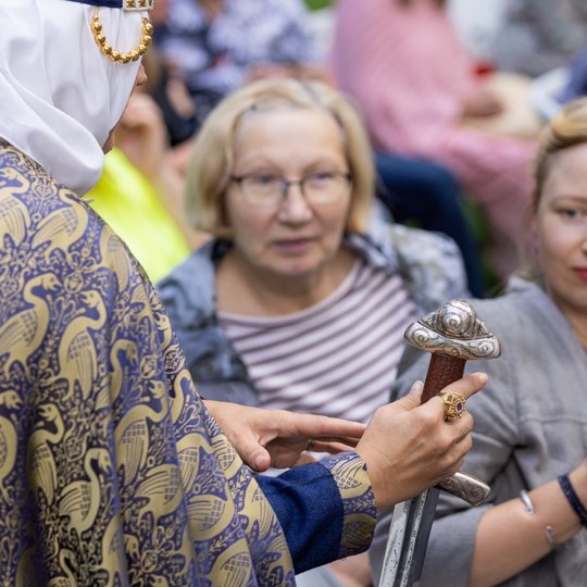 Paskaitos klausytojai apžiūri rodomą kalaviją.