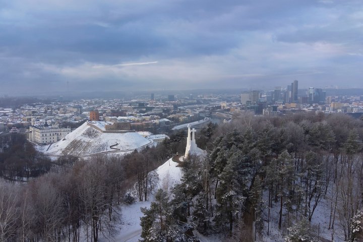 Apsnigtas Vilniaus pilių rezervatas diena. Nuotraukoje matosi Trijų Kryžių paminklas ir kalva bei Gedimino kalnas su bokštu. Tolumoje Vilniaus miesto panorama.