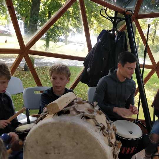 Užsiėmimo dalyviai muša būgnus Vilniaus pilių kupole.