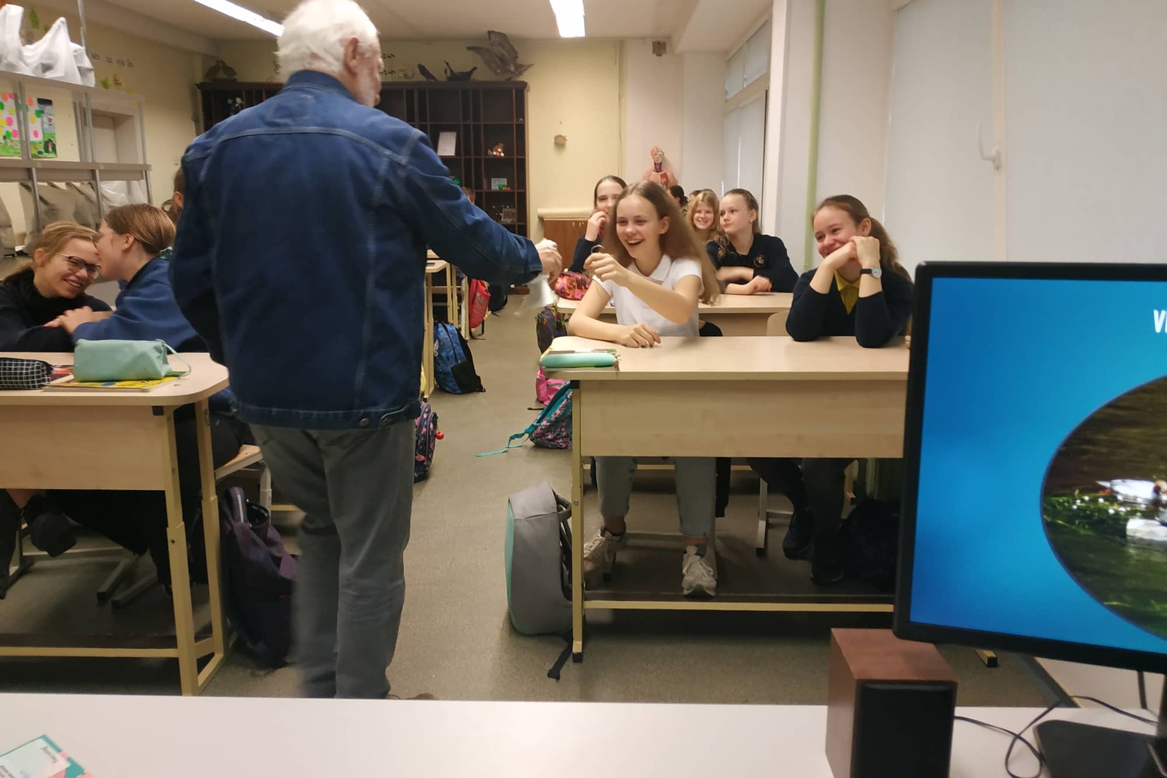 Edukatorius Stasys leidžia paglostyti balandį vaikams klasėje.