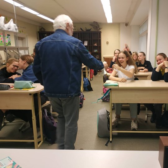 Edukatorius Stasys leidžia paglostyti balandį vaikams klasėje.