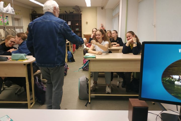 Edukatorius Stasys leidžia paglostyti balandį vaikams klasėje.