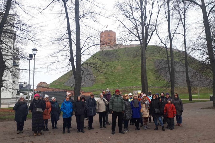 Sekmadienio ekskursijos grupė Pilių parke. Už jų matosi Gedimino pilies kalnas ir bokštas.