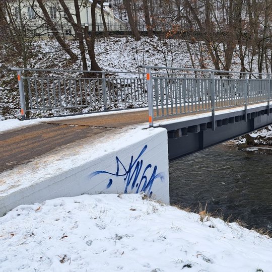 Lapkričio 29 dieną tiltas per Vilnios upę išpieštas graffiti piešiniais. Fotografuota iš šono.