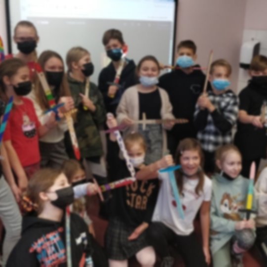 Vaikai pozuoja nuotraukai klasėje.