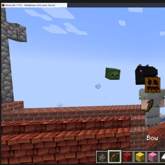 Minecraft žaidimo langas, kuriame ant Vilniaus pilių stogu žaidimo veikėjas su geležiniais šarvais ir ant galvos užsidėjęs moliūgą.