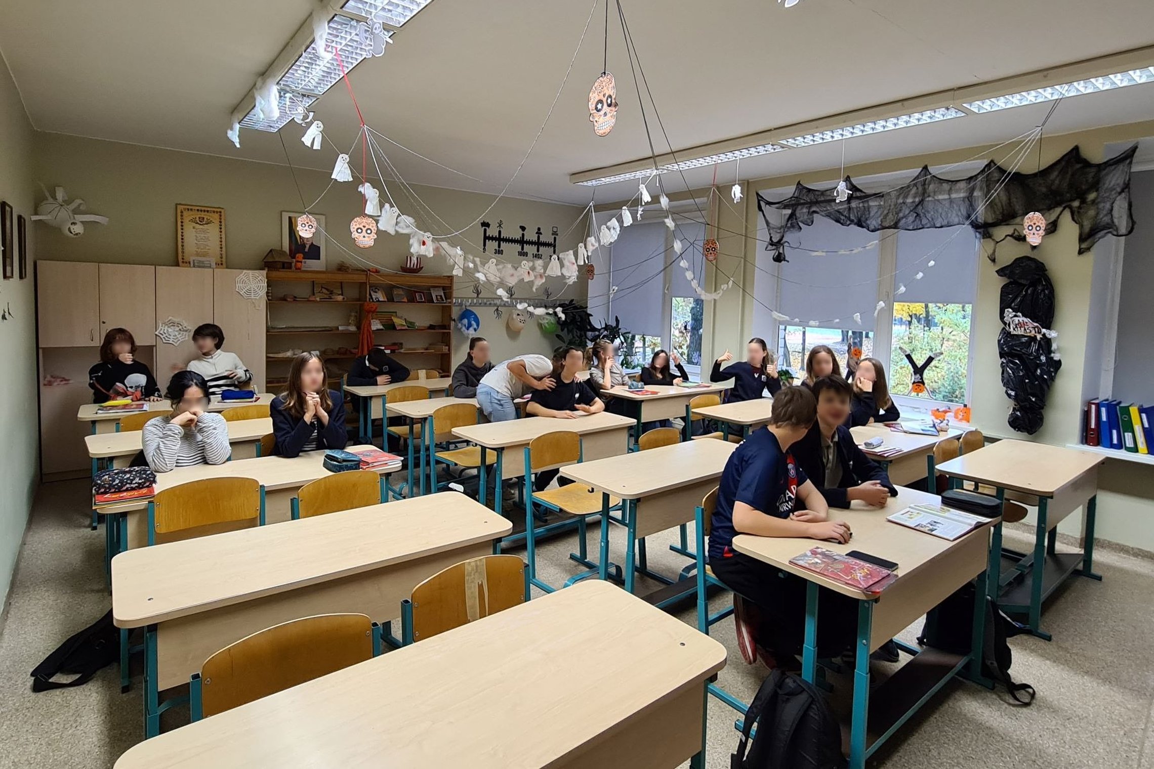 Per pertrauką klasėje kai kurie vaikai sėdi ir rašo, kai kurie kalbasi, o kiti vaikšto.