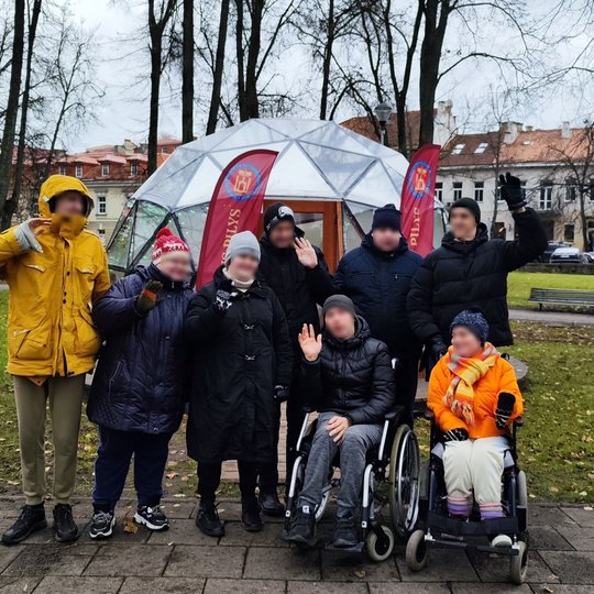 Markučių centro lankytojai prie Vilniaus pilių kupolo. Kai kurie iš jų mojuoja kamerai. Visi puikiai nusiteikę.