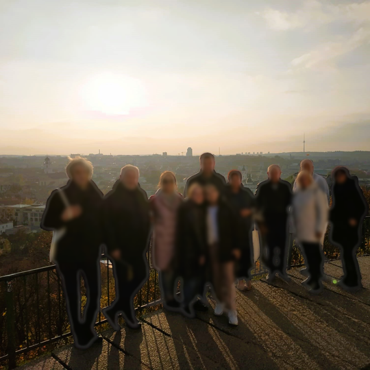 Ekskursijos dalyviai pozuoja nuotraukai priešais Trijų Kryžių paminklą.