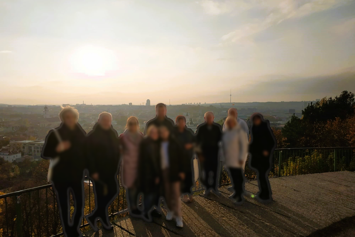 Ekskursijos dalyviai pozuoja nuotraukai priešais Trijų Kryžių paminklą.