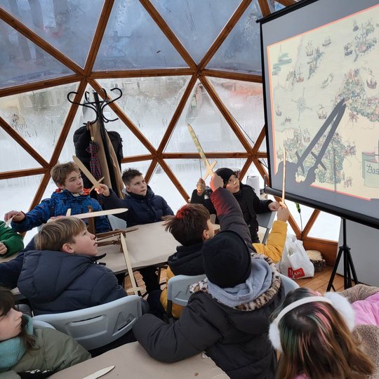 Mokiniai Vilniaus pilių kupole spalvina medinius kalavijus ir klausosi pasakojo.