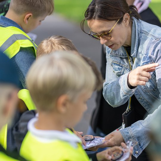 Kartu su edukatore mokiniai bando išsiaiškinti, kurioje pusėje yra šiaurė.