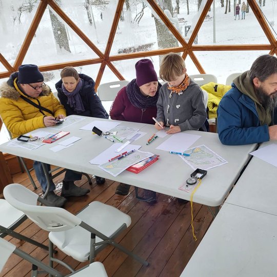 Edukacijos dalyviai įnirtikai nagrinėja rezervato žemėlapį Vilniaus pilių kupole. 
