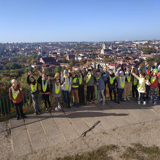 Ketvirtokai pozuoja nuotraukai  iškėlę rankas į virtų ant Trijų kryžių kalno.