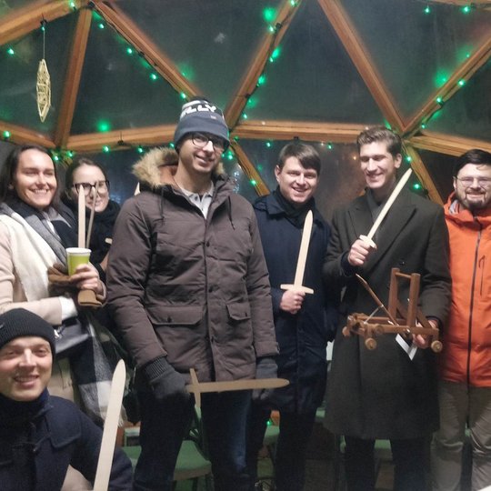 Gimtadienio dalyviai su mediniais kalavijais rankose pozuoja nuotraukai Vilniaus pilių kupole.