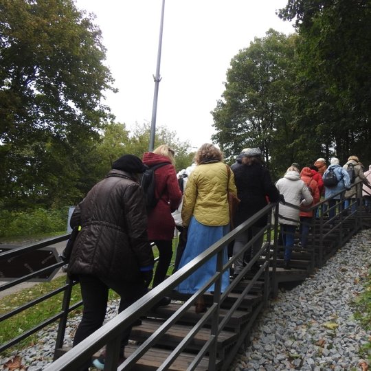 Gausus senjorų būrys susirinkęs į ekskursiją po Vilniaus Kreivąją pilį ir į žygį aplink Vilnią. Visi nuotraukoje nusisukę, nes nuotrauka daryta iš grupės galo, tačiau panašu, kad senjorai neblogai susitvarko su šią užduotimi ir niekas neatsilieka.