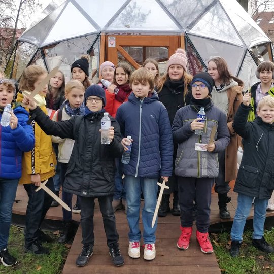 Mokiniai pozuoja nuotraukai priešais Vilniaus pilių kupolą.