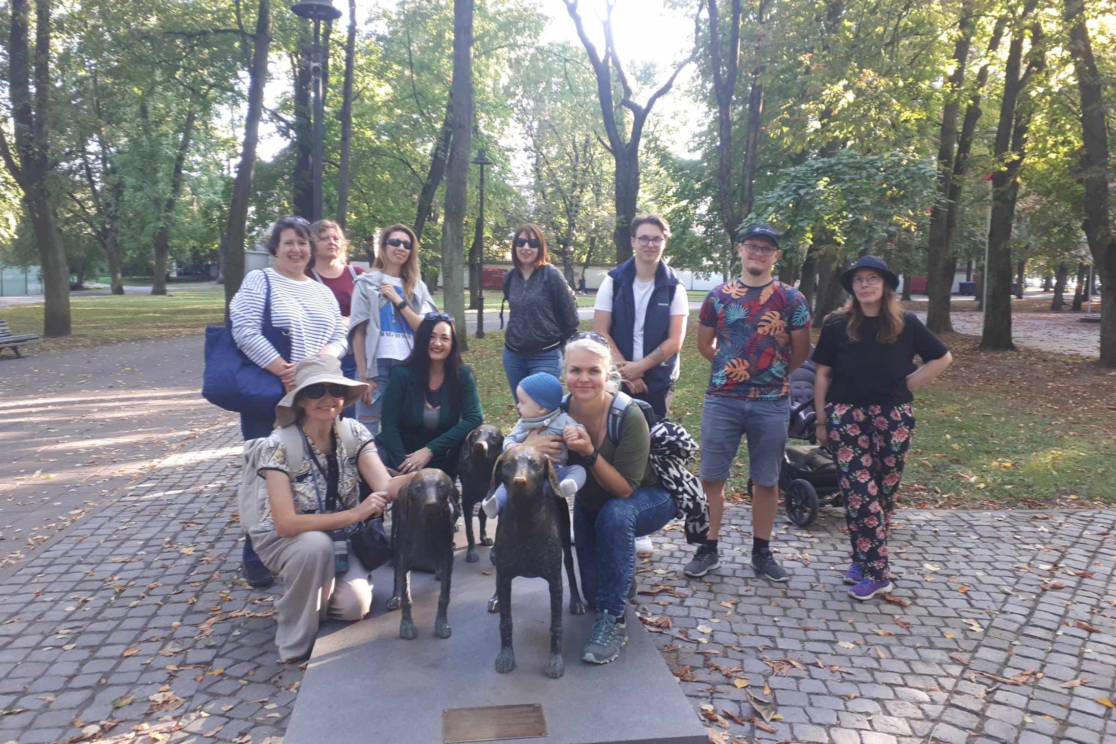 Dalyviai prie lietuviškų skalikų skulptūros Pilių parke.
