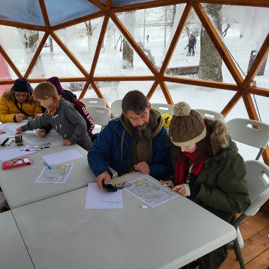 Vilniaus pilių kupole edukacijos dalyviai mokosi naudotis kompasu ir žemėlapiu.