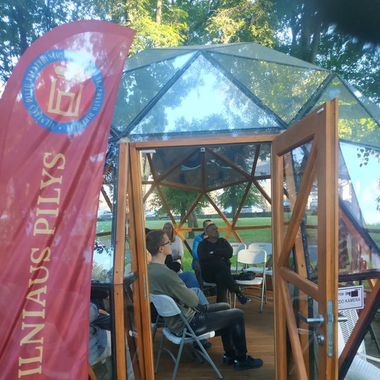 Vilniaus pilių kupole žmonės klausosi paskaitos.