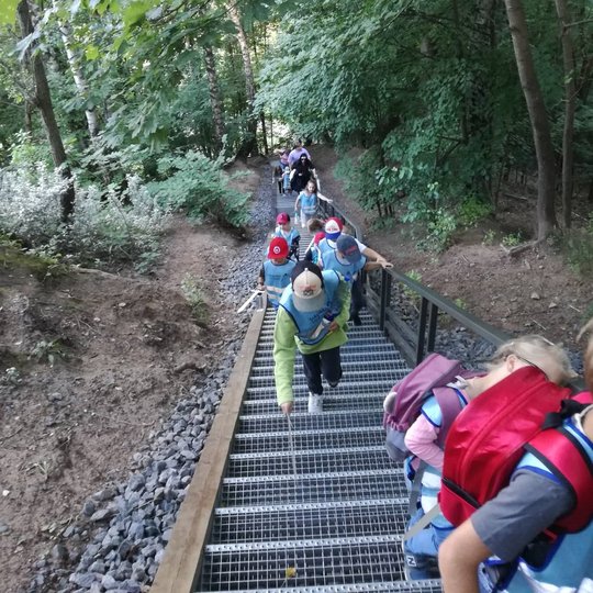 Vaikai, su mediniais kalavijais rankose, laiptais lipa į Altanos kalną.