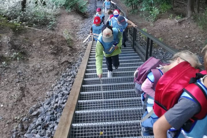 Vaikai, su mediniais kalavijais rankose, laiptais lipa į Altanos kalną.