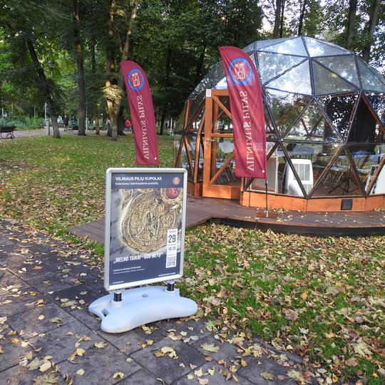 Vilniaus pilių kupolas iš lauko. Šalia kupolo paskaitos afiša.