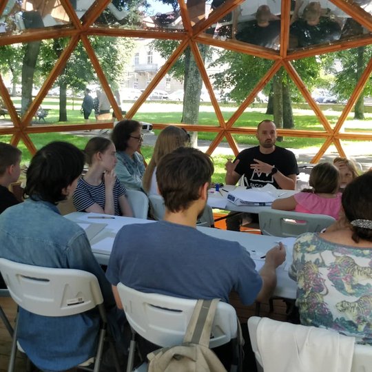Vilniaus pilių kupolas pilnas prie stalų sėdinčių žmonių.