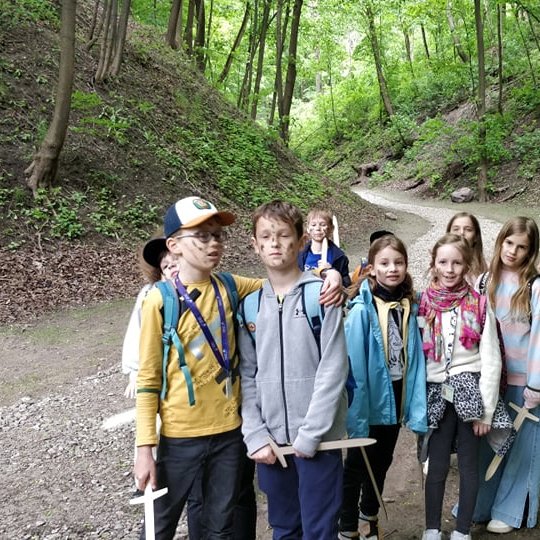 Vaikai su mediniais kalavijais pozuoja nuotraukai prieš Didžiąją Griovą.