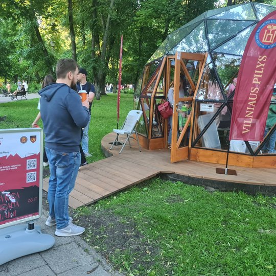 Vyriškis gerdamas kavą, domisi kas vyksta Vilniaus pilių kupole. 