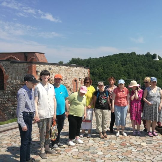 Ekskursijos dalyviai sustoje pozuoja ant Gedimino kalno viršutinėje terasoje. Fone matosi Trijų Kryžių paminklas.