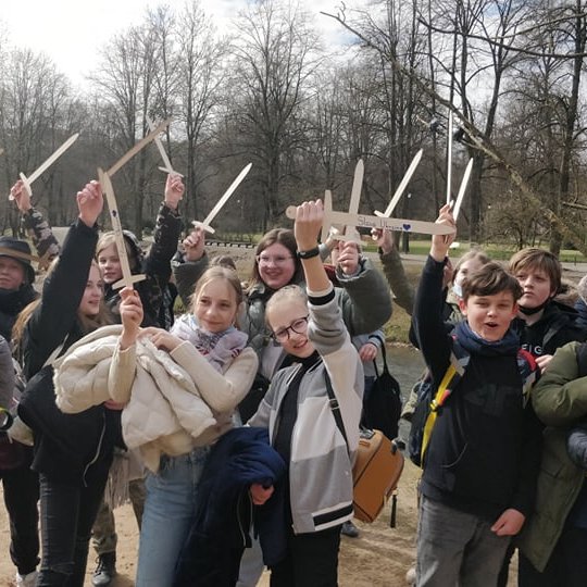 Penktokai, iškėlę medinius kalavijus į viršų, pozuoja nuotraukai šalia bernardinų sodo.