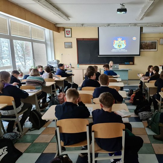 Vyksta istorijos pamoka. Mokiniai klausosi istorijos mokytojos.
