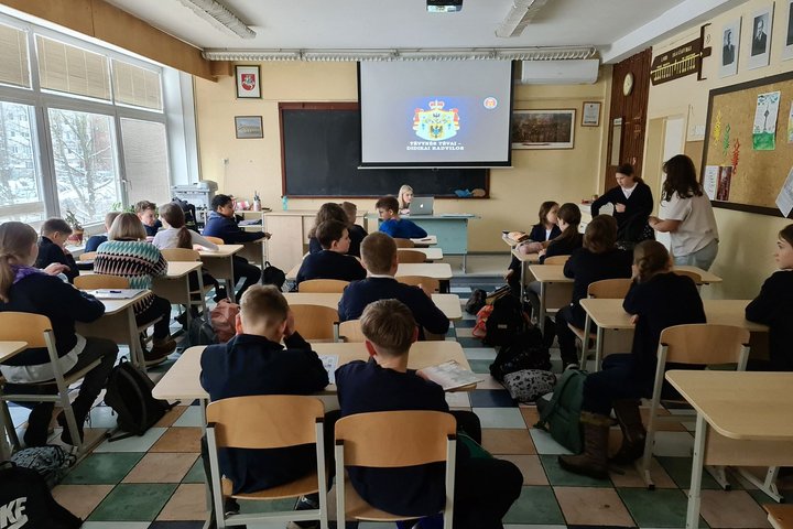 Vyksta istorijos pamoka. Mokiniai klausosi istorijos mokytojos.