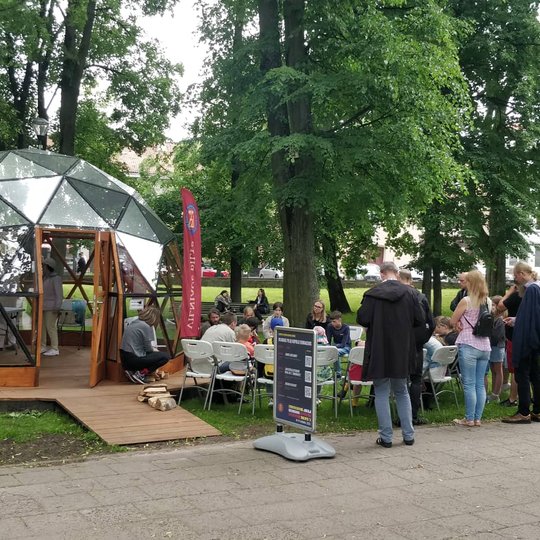 Vilniaus pilių kupolas, dešinėje susirinkę klausosi edukacijų žmonės.
